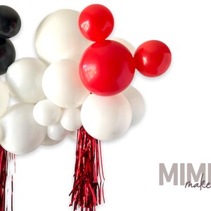 May include: A red and white balloon garland with red streamers. The balloons are arranged in the shape of Mickey Mouse's head.  The garland is perfect for a birthday party or other celebration.