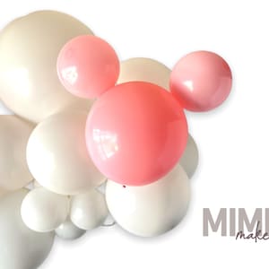 May include: A cluster of white, cream, and pink balloons, arranged in a decorative display. The balloons vary in size, with the largest ones in cream and white. The text "MIMI maker" is visible in the lower right corner.