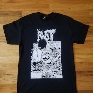 May include: Black t-shirt with a white graphic print of a band logo and a scene with a person in a helmet and a tree. The band name is "RUST" in a stylized font.