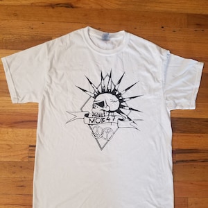 May include: White t-shirt with a black and white graphic of a skull with a mohawk, a banner that says "MOB 47", and a peace sign.