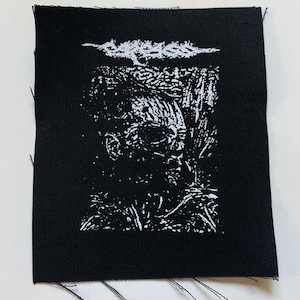 Könnte beinhalten: Schwarz-weiß gestickter Patch mit einem detaillierten Design eines Totenkopfs und gekreuzter Knochen. Der Patch ist aus schwarzem Stoff mit weißen Stickereien.