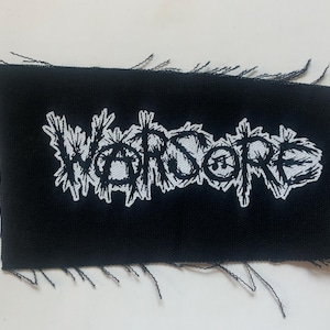 May include: Black fabric patch with white embroidered text that reads "WARSORRE".