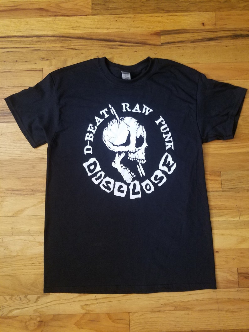 May include: Black t-shirt with a white graphic of a skull holding a microphone and the text "D-Beat Raw Punk Disclose"