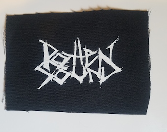Peut inclure: Écusson de groupe "Rotten Sound" en blanc sur fond de tissu noir.