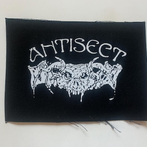 May include: Black patch with white text that reads "ANTISECT" and a white graphic of a skull with horns.