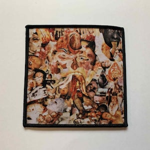May include: Square patch featuring a collage of human faces and body parts in shades of brown, beige, and red, with a black border. The design presents a macabre or surreal artistic style.