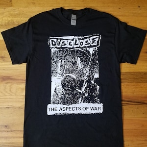 May include: Black t-shirt with a white graphic print of a band called "DISCLOSE" and the text "THE ASPECTS OF WAR".