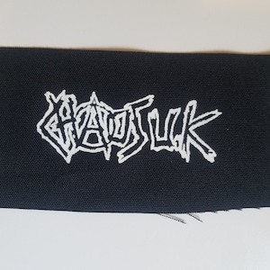Op de afbeelding: Zwarte stoffen patch met witte geborduurde tekst die "GHOULSUCK" luidt.