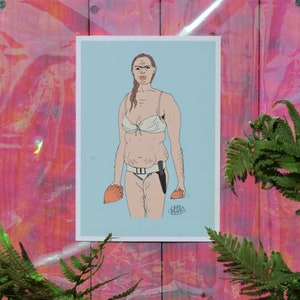 May include: A print featuring a cartoon illustration of a person in a white bikini and holding a knife and an orange object. The artwork is set against a light blue background and framed in white.