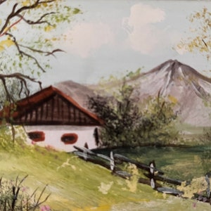May include: A painting depicting a white cottage with a brown roof, situated against a background of green hills and a snow-capped mountain. The cottage features two windows and a fence in front.