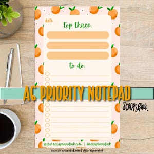May include: A5 priority notepad with a peach pattern. The notepad has a pink background with orange peaches and green leaves. The notepad includes sections for "top three" and "to do" lists, with the text "date" at the top.