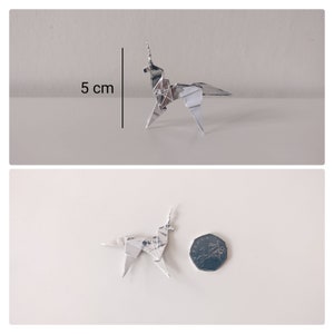 May include: A silver origami unicorn, approximately 5 cm tall, is shown next to a British 50 pence coin for scale.