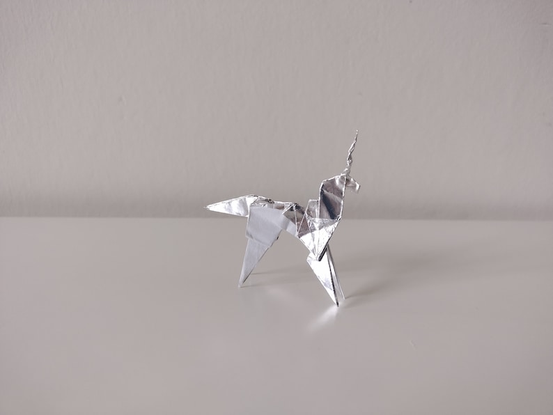 May include: A silver origami unicorn, a traditional Japanese paper folding art form.