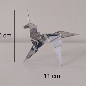 May include: A silver origami unicorn, 10 inches tall and 11 inches wide.