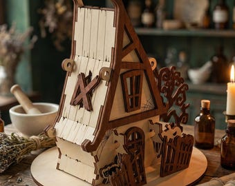 May include: A detailed wooden model of a house, featuring light wood panels and dark brown trim. The house has a decorative roof, a door, and a fence. It is set on a round wooden base. Candles and scrolls are visible in the background.