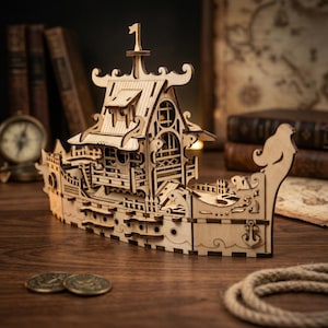 Puede incluir: Maqueta de barco de madera con detalles intrincados, incluyendo una cabina, mástiles y tallas decorativas. El barco es de madera clara y está sobre una superficie de madera. Una luz cálida ilumina el interior de la cabina.