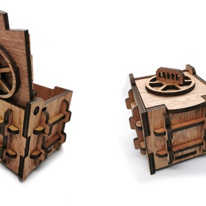 May include: A wooden box shaped like a safe with a round, rotating dial and a hinged lid. The box is made of light brown wood with dark brown accents.
