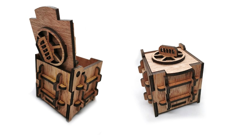 May include: A wooden box shaped like a safe with a round, rotating dial and a hinged lid. The box is made of light brown wood with dark brown accents.