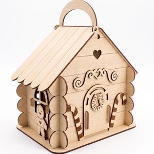 A wooden toy house with a gingerbread man figure on the side.