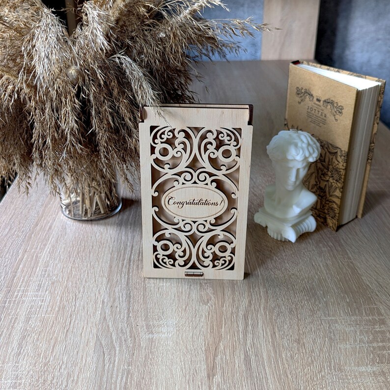 May include: A wooden box with a decorative cutout design and the words "Congratulations!" engraved on the front.