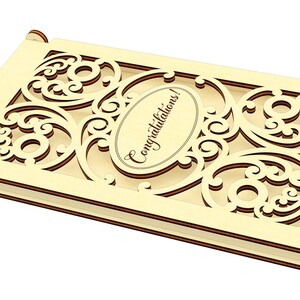 May include: A wooden box with a decorative cutout design and the word "Congratulations!" inscribed on the front. The box is light brown and has a hinged lid.