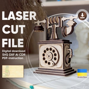 Op de afbeelding: Een laser-snijbestand voor een model van een vintage draaitelefoon van hout. Het bestand bevat de formaten SVG, DXF, AI en CDR, evenals PDF-instructies. De afbeelding toont een voltooid model van de telefoon op een boek.