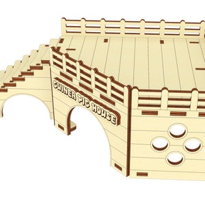 May include: Wooden guinea pig house with a ramp, a platform, and a large arched entrance. The house is painted in a light wood color with brown accents. The text "Guinea Pig House" is printed on the front of the house.