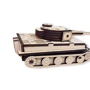 May include: A wooden model of a German Tiger tank. The tank is made of multiple layers of wood and has a detailed design. The tank is painted in a light brown color and has a black gun barrel.