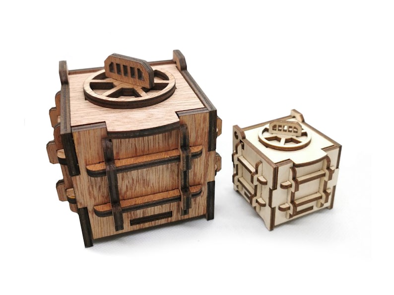 May include: Two wooden safes with intricate details. The larger safe is brown and the smaller safe is natural wood.