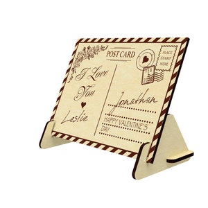 May include: A wooden postcard with a vintage design featuring the text "I Love You" and "Happy Valentine's Day". The postcard is standing on a wooden easel.