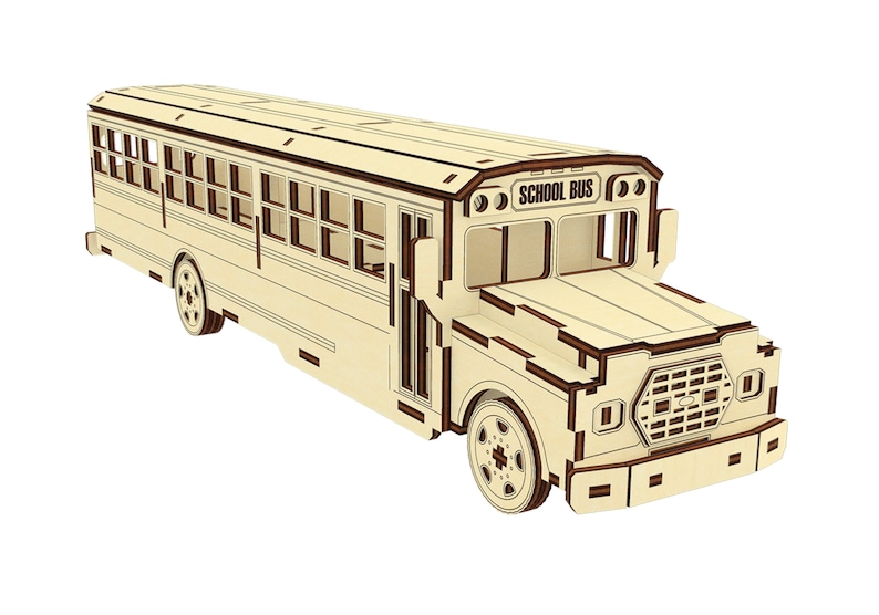 Puede incluir: Un modelo de madera de un autob&uacute;s escolar amarillo con ribetes marrones. El autob&uacute;s tiene ventanas en los lados y un letrero de "SCHOOL BUS" en la parte delantera.