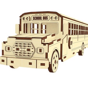 Puede incluir: Un kit de modelo de madera de un autob&uacute;s escolar amarillo con las palabras "SCHOOL BUS" impresas en la parte delantera. El autob&uacute;s tiene una se&ntilde;al de stop en el lateral y una parrilla delantera detallada.