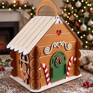 A wooden gingerbread house-shaped toy with a red heart on the front door, placed on a wooden surface with a Christmas tree and twinkling lights in the background.