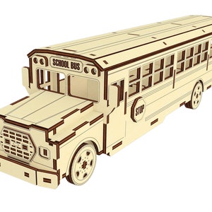 Puede incluir: Un modelo de madera de un autob&uacute;s escolar amarillo con ribetes marrones. El autob&uacute;s tiene un letrero de "SCHOOL BUS" en la parte delantera y un letrero de "STOP" en el lateral. El autob&uacute;s tiene ventanas y ruedas.