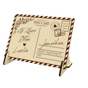 May include: A wooden postcard with a vintage design. The postcard says "I Love You" and "Happy Valentine's Day". The postcard is addressed to "Jonathan" from "Leslie".