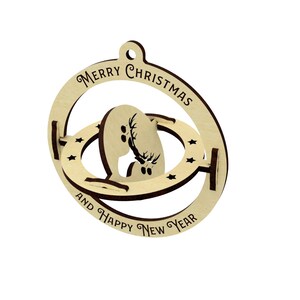 Puede incluir: Adorno navide&ntilde;o de madera con la silueta de un reno dentro de un dise&ntilde;o de herradura. El adorno tiene las palabras "MERRY CHRISTMAS AND HAPPY NEW YEAR" grabadas alrededor del borde. El adorno es de madera clara.