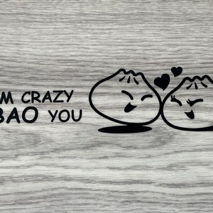 May include: Two cartoon bao buns with smiling faces and hearts above them. The text "I'M CRAZY ABAO YOU" is written below the buns.