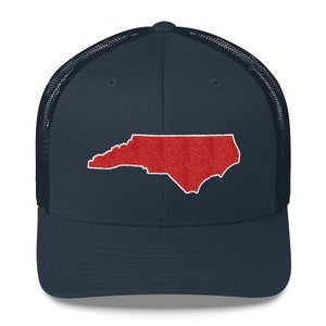 Pu&ograve; includere: Un cappello da camionista blu navy con un contorno ricamato rosso dello stato della Carolina del Nord.