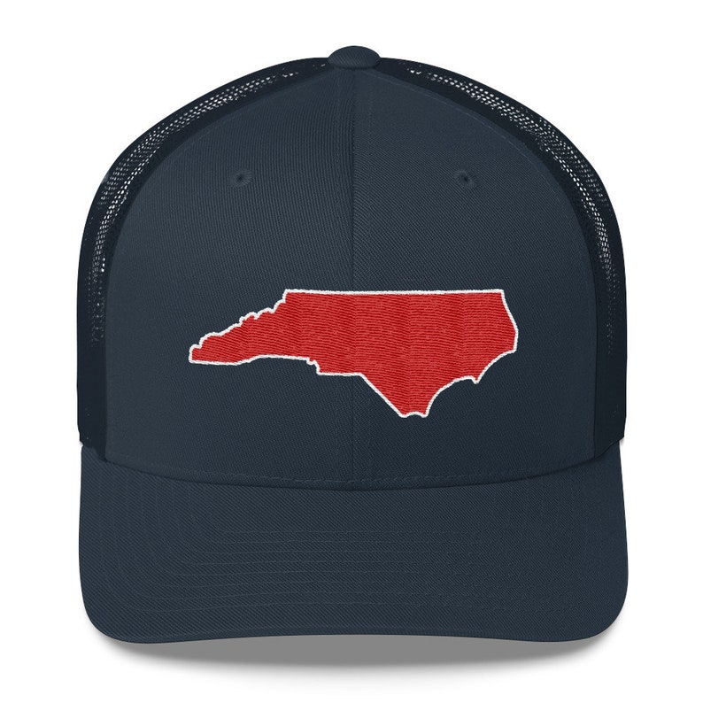 Pu&ograve; includere: Un cappello da camionista blu navy con un contorno ricamato rosso dello stato della Carolina del Nord.