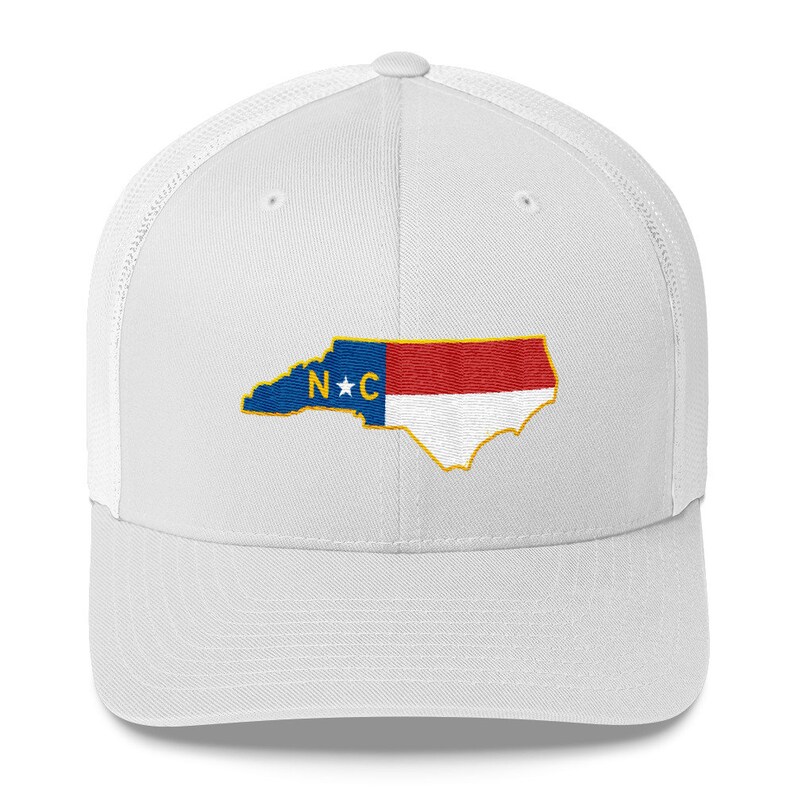 May include: White trucker hat with a blue, red, and white embroidered North Carolina state outline with a star and the letters "N*C" in the center.