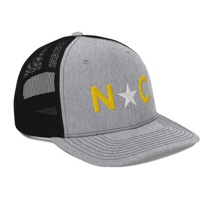 May include: A gray and black trucker hat with a yellow embroidered "N*C" on the front.