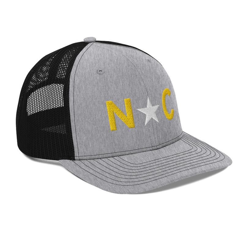 May include: A gray and black trucker hat with a yellow embroidered "N*C" on the front.