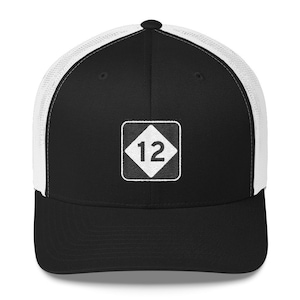 May include: Black and white trucker hat with a white diamond-shaped patch featuring the number 12 in the centre.