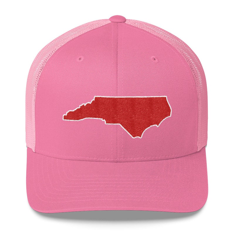 Pu&ograve; includere: Cappellino da camionista rosa e nero con un contorno ricamato rosso dello stato della Carolina del Nord.