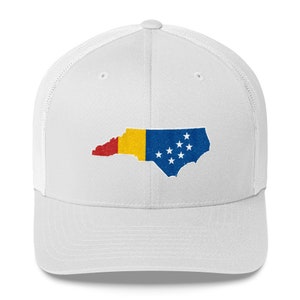 May include: White trucker hat with a white embroidered outline of the state of North Carolina, filled with the colours of the Romanian flag. The hat has a mesh back.