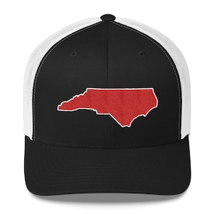 Może przedstawiać: Czarna i biała czapka trucker z haftowanym czerwonym obrysem stanu Karolina Północna.