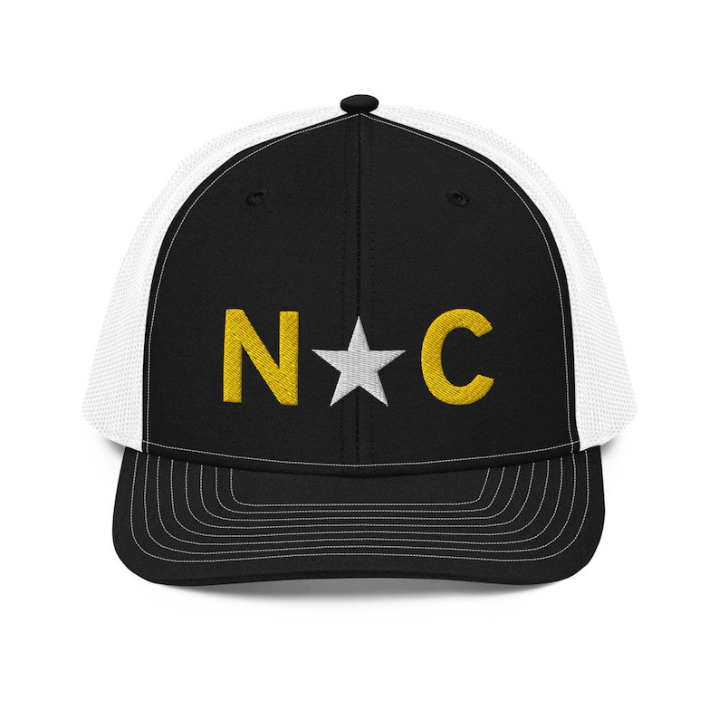May include: Black and white trucker hat with a gold embroidered "N*C" logo.
