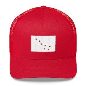 May include: Red trucker hat with a white patch featuring a red star design. The patch is centered on the front of the hat.