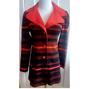 Peut inclure: Un manteau vintage rayé avec un col rouge et des boutons rouges. Le manteau est à rayures noires et brunes.