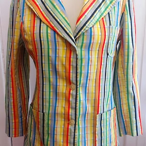 Peut inclure: Un blazer rayé avec un fond jaune et des rayures verticales colorées. Le blazer a une fermeture à boutons et deux poches.